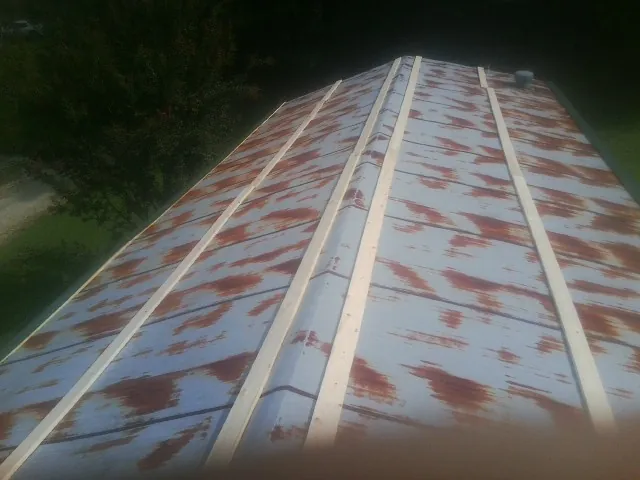 Rusted metal roof panels with new wood purlins before replacement — Storm Damage Roof Repair in Vale by Roofing Brothers